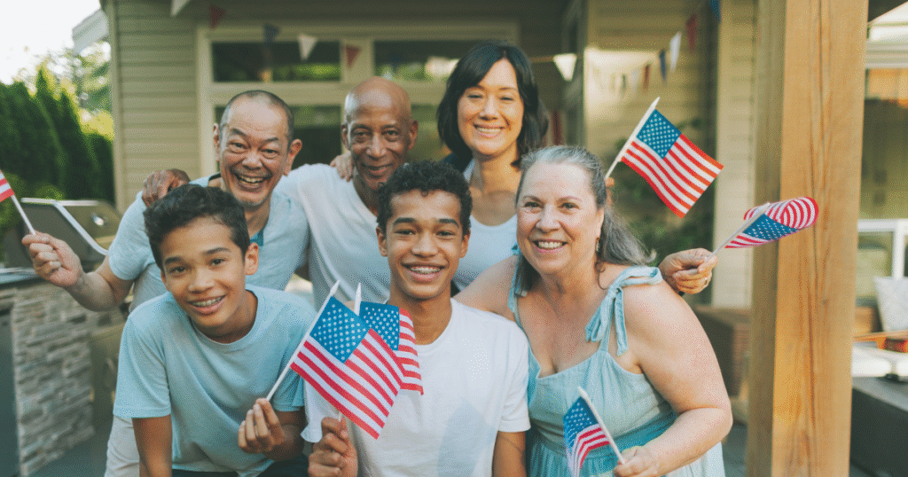 Multigenerational American family celebrating together with U.S. flags, representing diversity, immigration, and community in the U.S. immigration decline 2025 context.